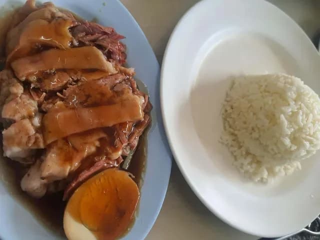 ข้าวขาหมูพะโล้ราดน้ำ มีไข่พะโล้ผ่าครึ่ง วางคู่ข้าวสวยจานแยก