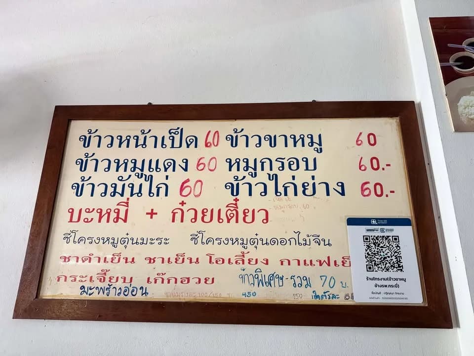 ป้ายเมนูในร้าน กรอบไม้ เขียนข้าวหน้าเป็ด ข้าวขาหมู ข้าวหมูแดง หมูกรอบ ข้าวมันไก่ ข้าวไก่ย่าง ราคา 60 บาท และป้าย Thai QR Payment